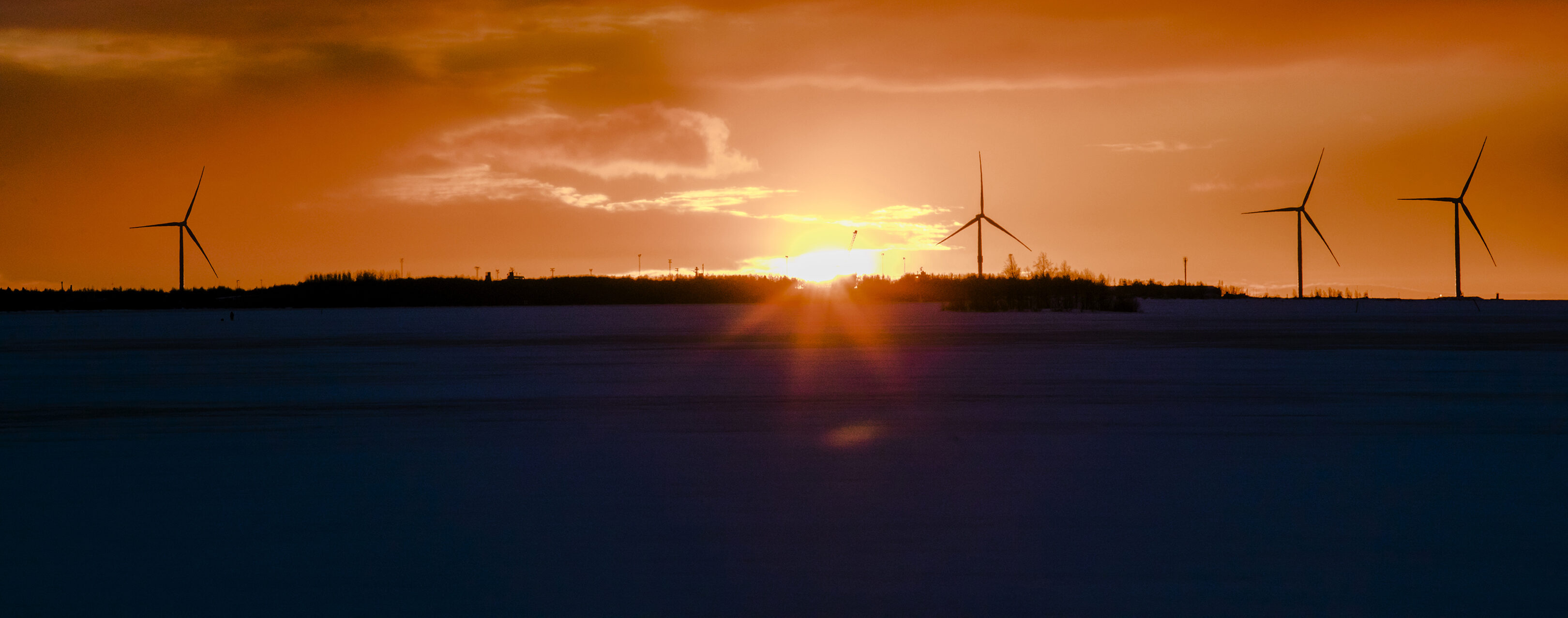 Solnedgång och vindmöllor på vintern.