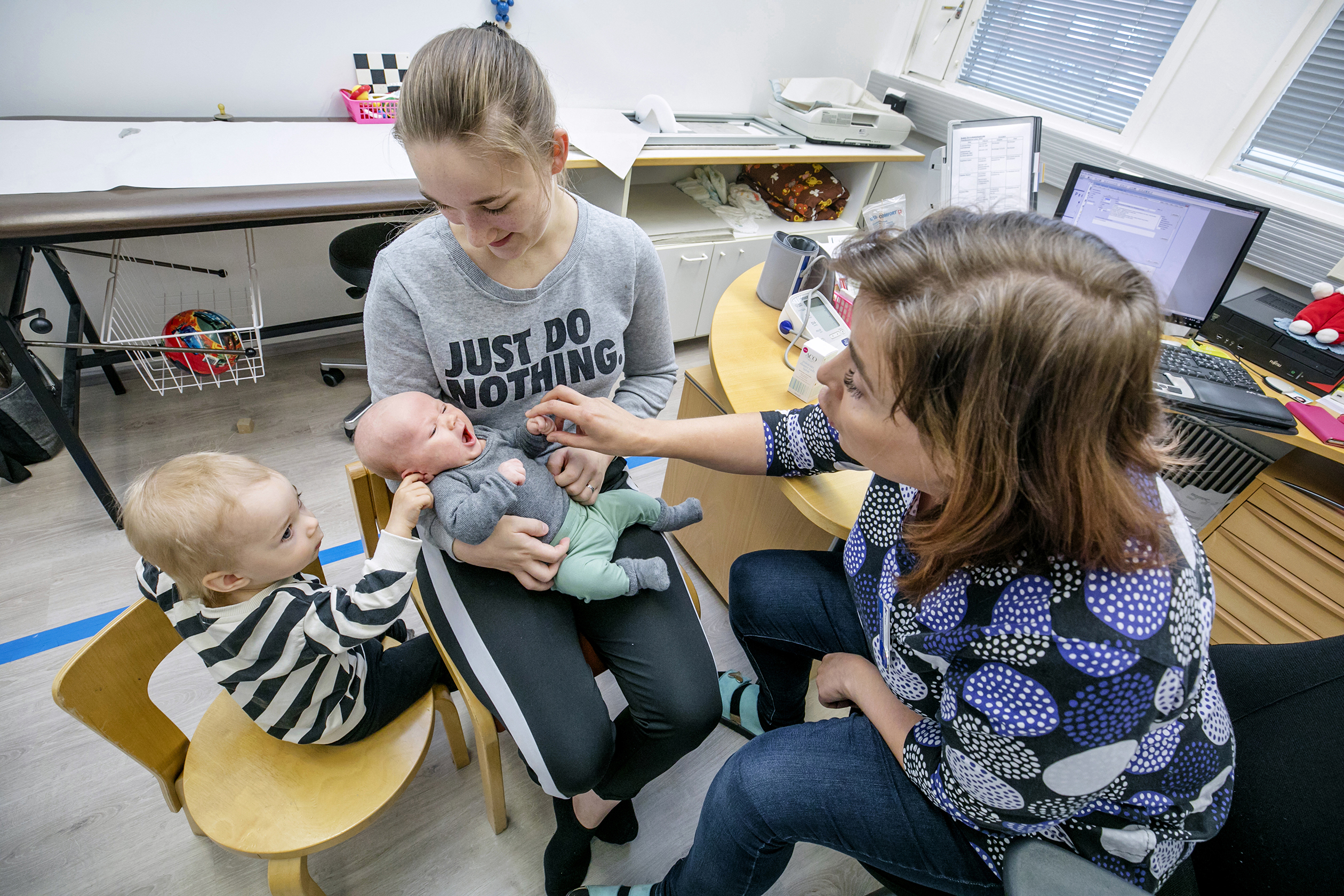 Äiti on tuonut vauvan ja 1,5-vuotiaan lastenneuvolaan. Terveydenhoitaja tutkii.