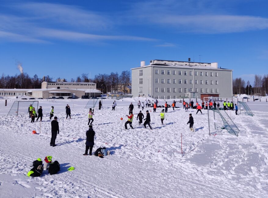 Ihmisiä aurinkoisessa talvimaisemassa.